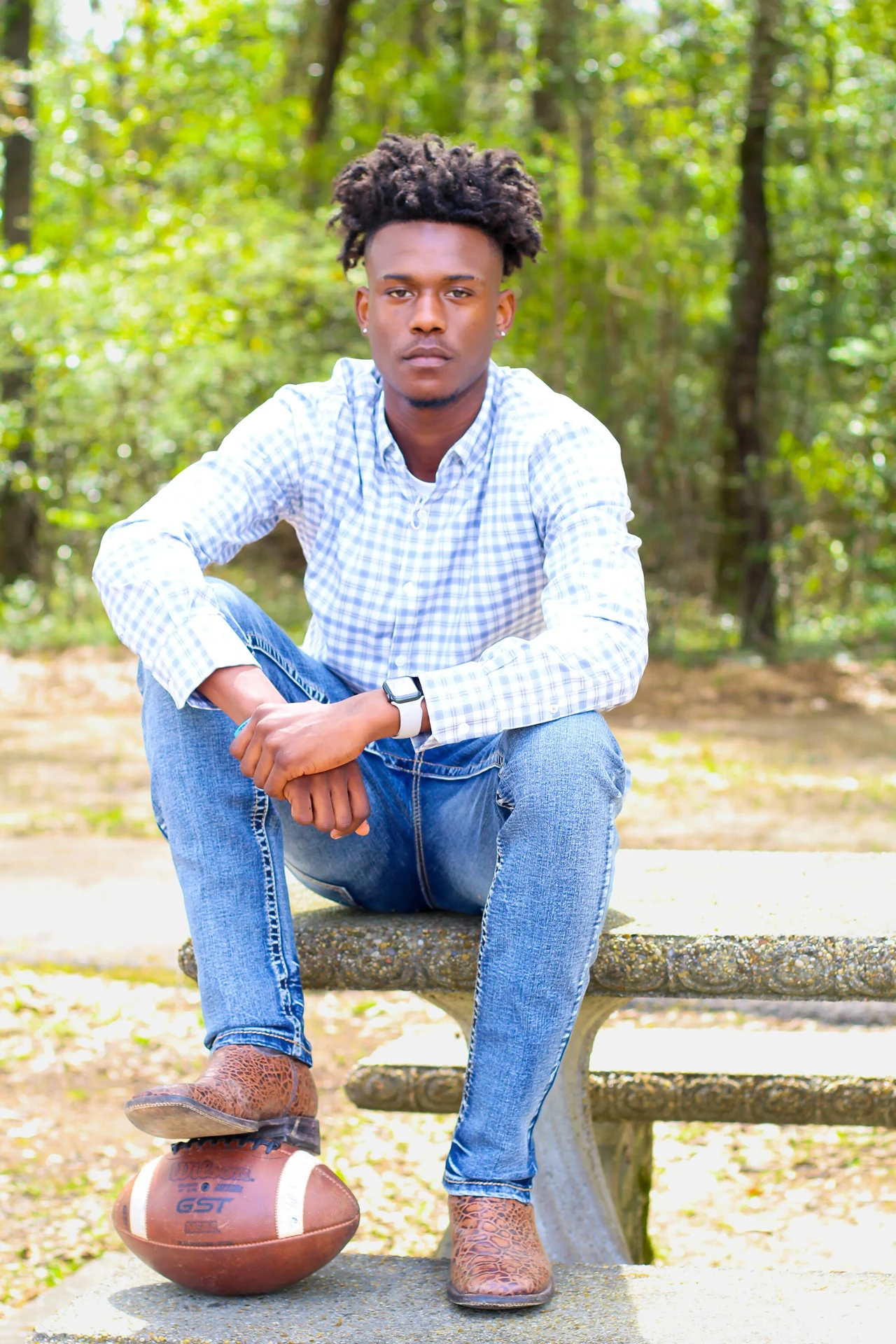 Senior session photograph with a football outdoors