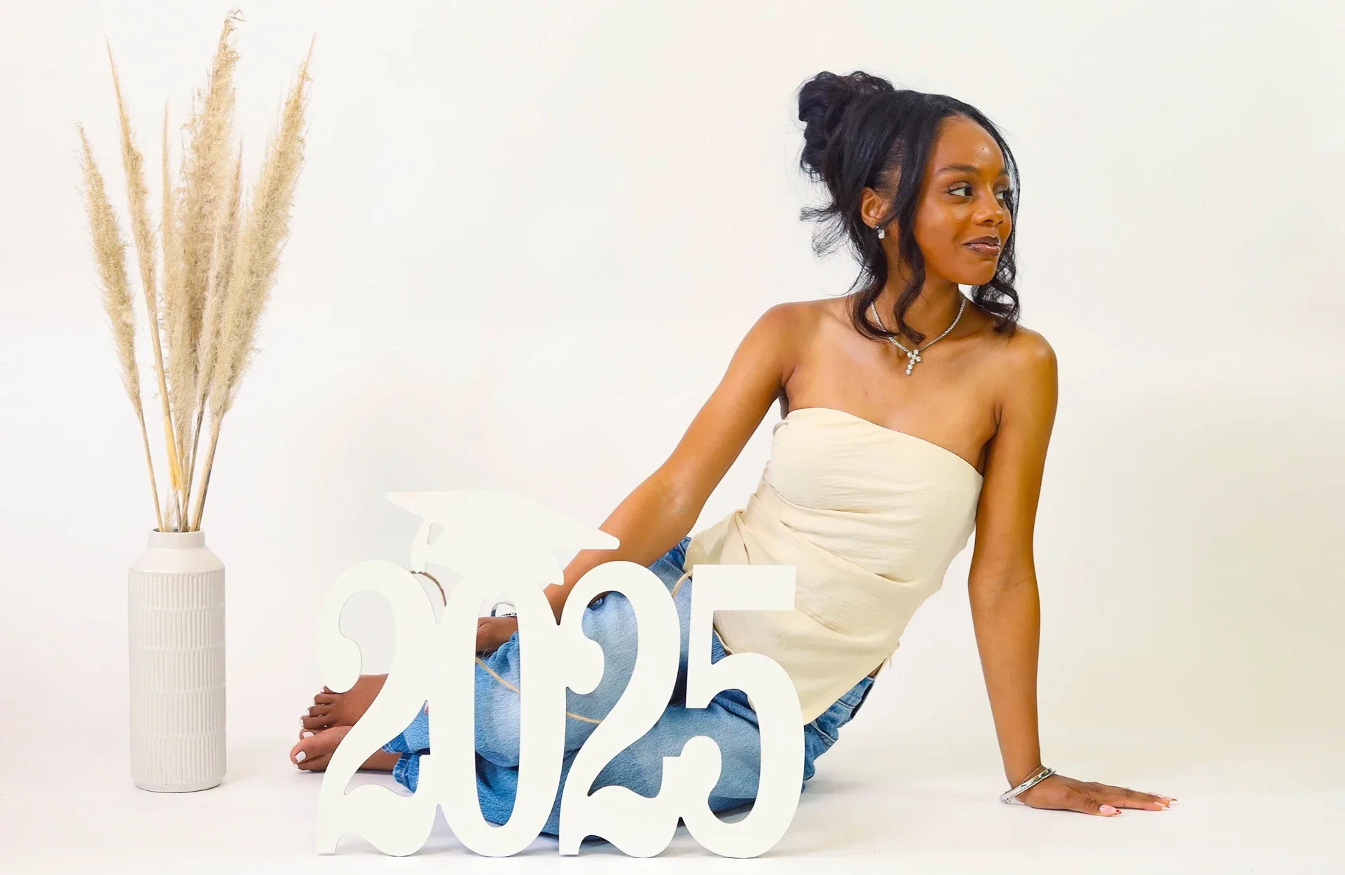 Graduation session photograph with a 2025 sign in studio