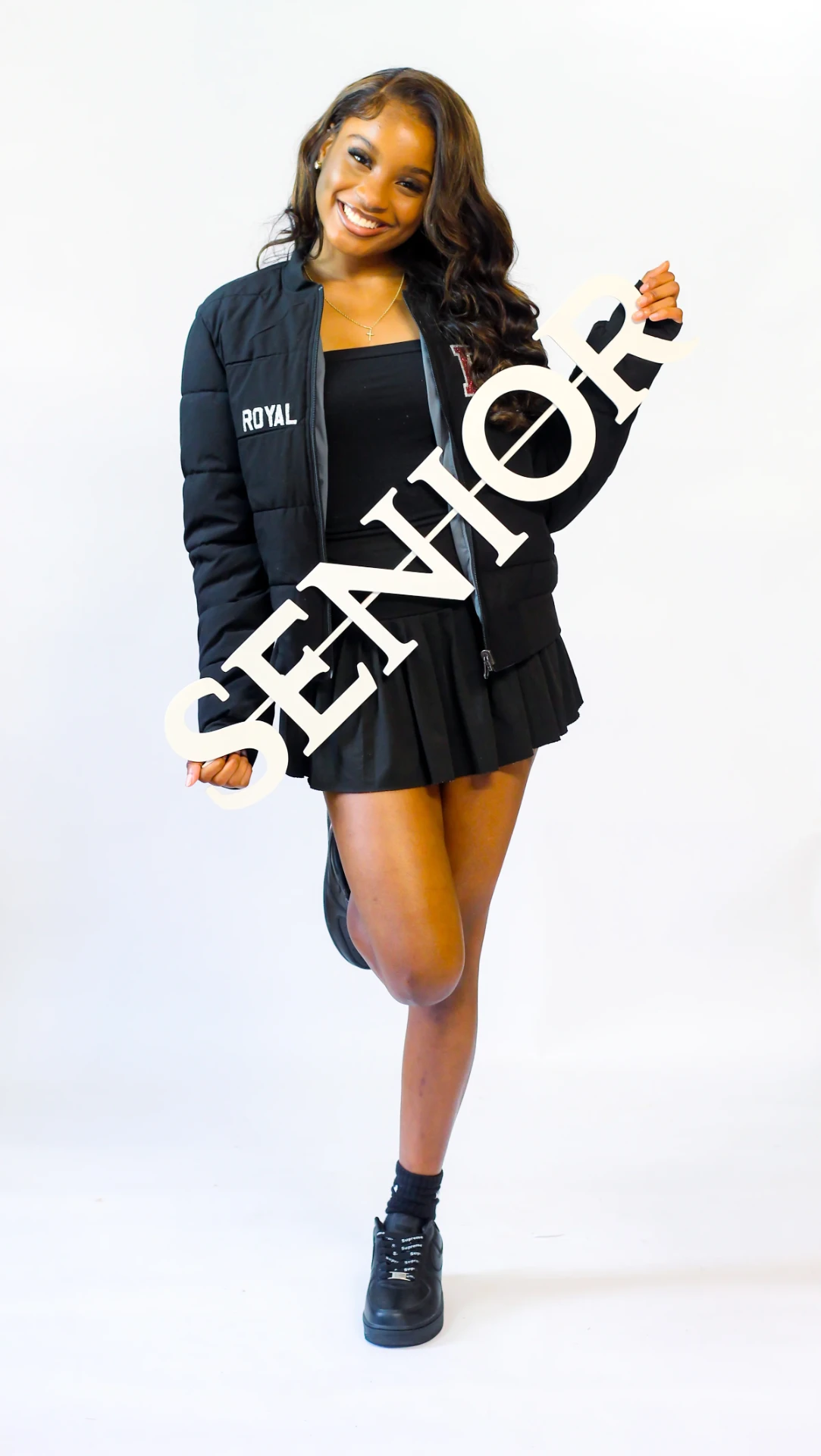 Senior session photograph with a SENIOR sign in studio